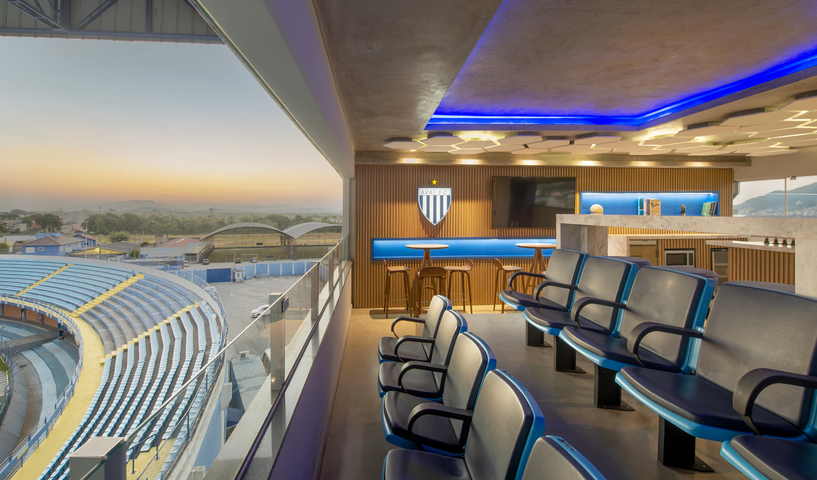 Poltronas do camarote com vista para o gramado e o pôr do sol