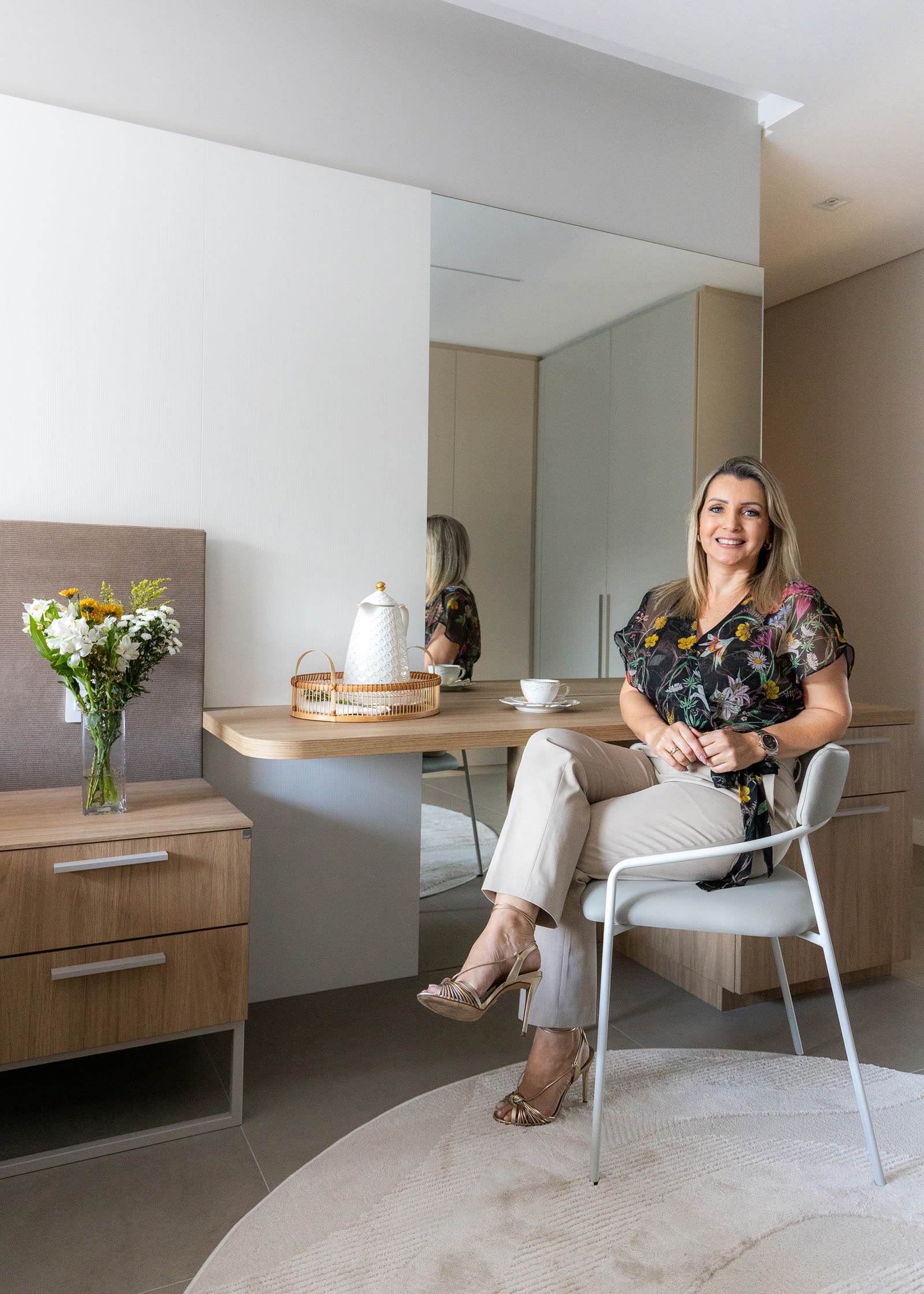 Jeane Silva sentada em bancada de apartamento projetado por ela em Jurerê Internacional