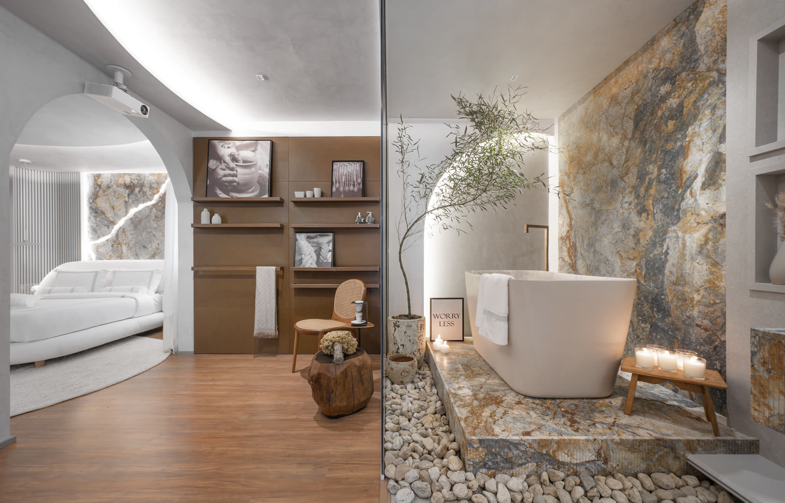 Banheira solta junto ao quarto, com seixos e oliveira decorativa